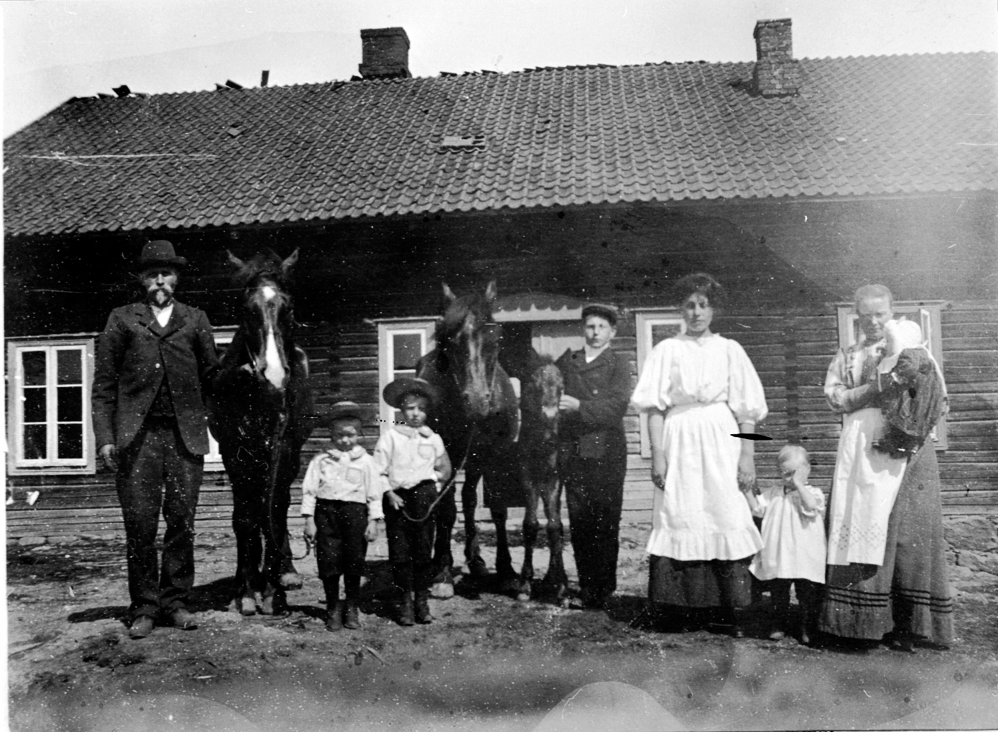 Bilde av mennesker foran hus