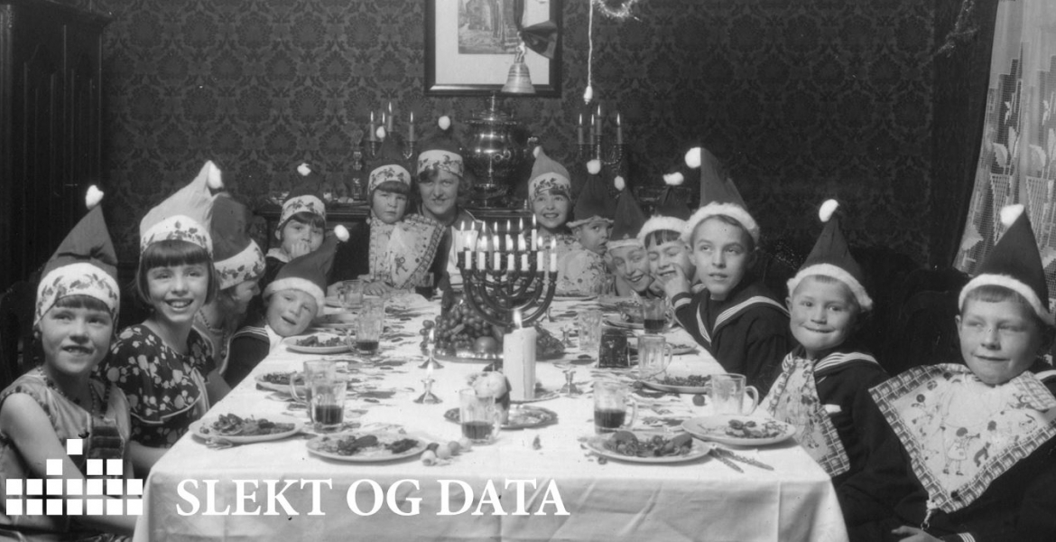Julekort fra Slekt og Data. Bilde av juleselskap med barn utkledd som nisser.